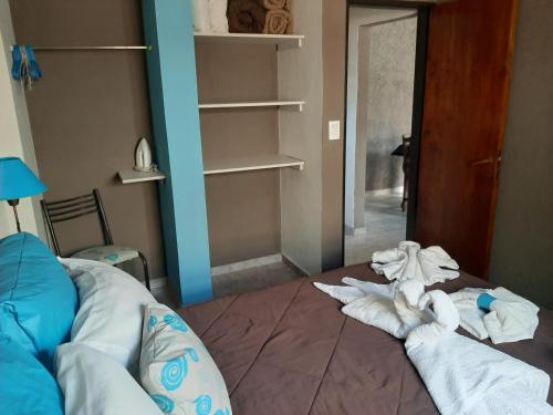 a bedroom with a bed with towels on the floor at Complejo Los Cipreses in Villa Carlos Paz