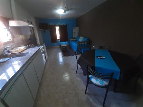 a kitchen with a table and a blue table and chairs at Complejo Los Cipreses in Villa Carlos Paz