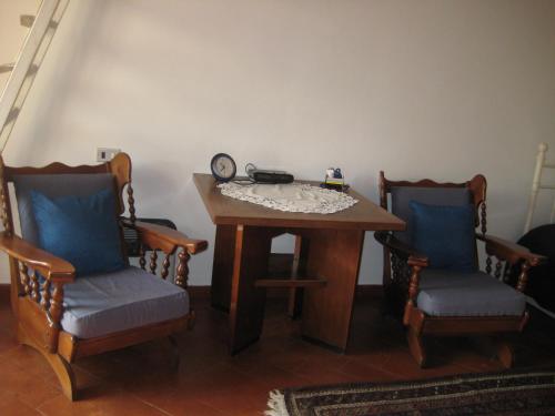 a table with two chairs and a clock on it at Casa Messi in Pitigliano