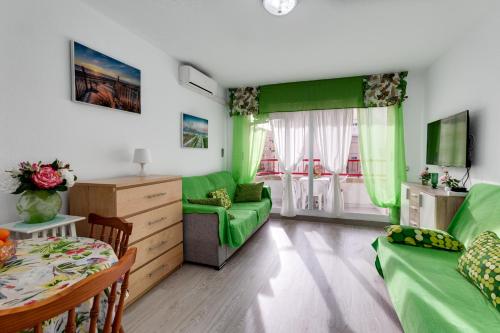 - un salon vert avec un canapé et une table dans l'établissement Apartment Studio Playa del Cura, à Torrevieja