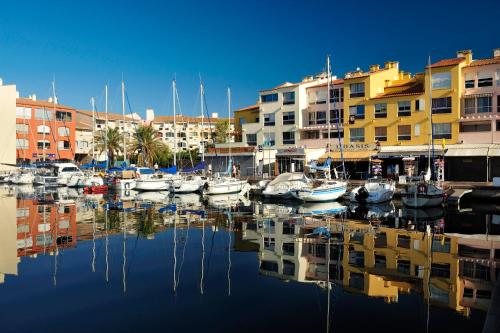 a group of boats docked in a marina with buildings at Appart'Hôtel Agathea in Cap d'Agde
