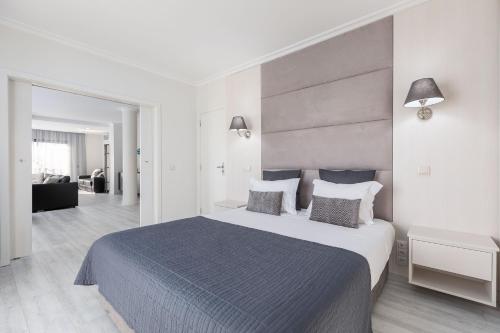 a bedroom with a large bed and a living room at D_Loft in Albufeira