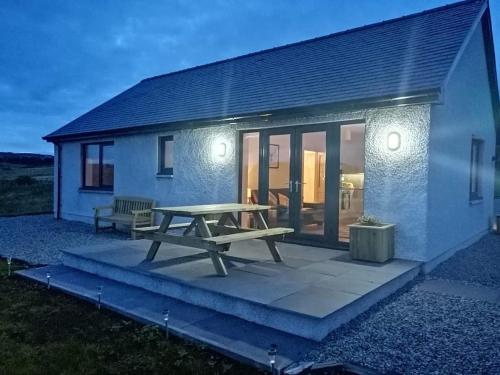 a picnic table on a patio in front of a house at Poachers Bothy in Skeabost