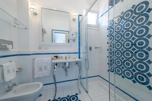 a white bathroom with a sink and a shower at Hotel Onda Verde in Praiano