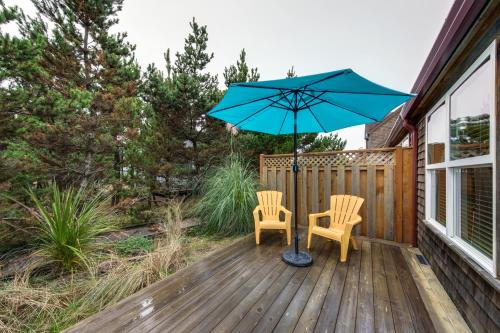 a patio with two chairs and an umbrella on a deck at Beachcomber's Paradise in Pacific City