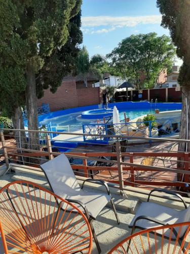 a swimming pool with chairs and a swimming pool at Complejo Los Cipreses in Villa Carlos Paz