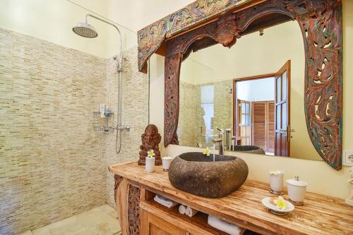 a bathroom with a sink and a large mirror at Villa Bidadari - Bali Sea Villas Beachfront and private pool in Pengastulan