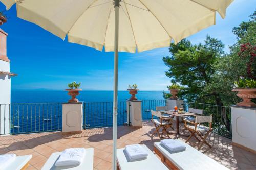 a patio with a table and an umbrella at Hotel Onda Verde in Praiano