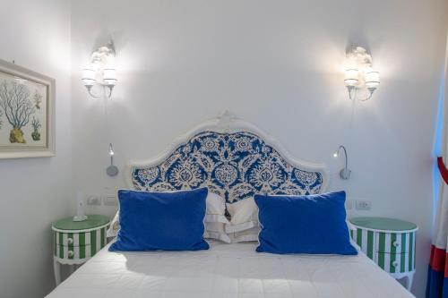 a bedroom with a blue and white bed with two tables at Hotel Onda Verde in Praiano