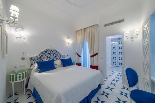 a blue and white bedroom with a bed and a table at Hotel Onda Verde in Praiano