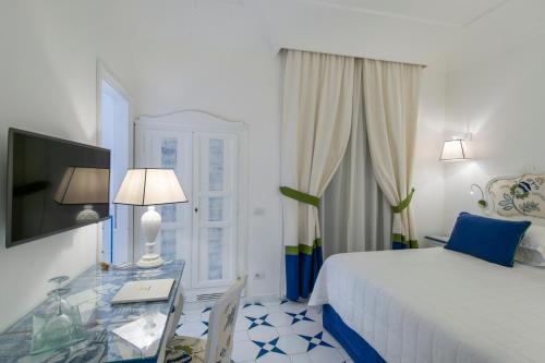 a hotel room with a bed and a glass table at Hotel Onda Verde in Praiano