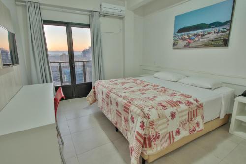 a white bedroom with a bed and a window at Life Hotel Torres in Torres
