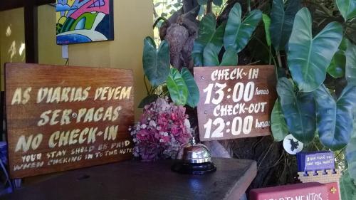 a table with two signs and flowers on it at Apart Hotel Casa Grande in Natal