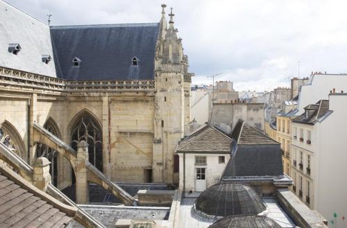 a view of a cathedral from the roofs of buildings at Hôtel Le Presbytère in Paris