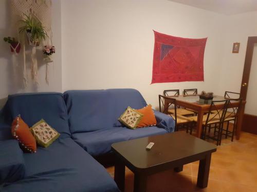 sala de estar con sofá azul y mesa en Apartamento El Portiel, en Gotor