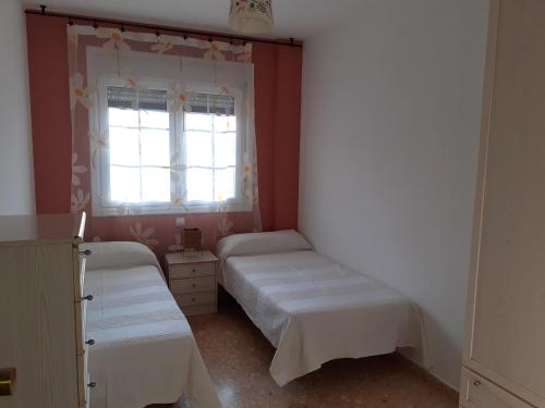 1 dormitorio con 2 camas y ventana en Apartamento El Portiel en Gotor