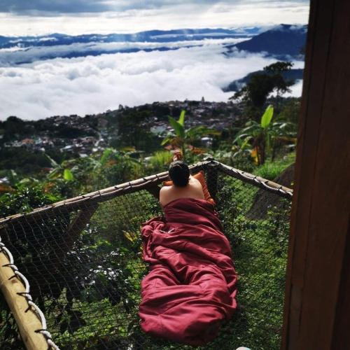 a man laying on a hammock on top of a mountain at Monte Mágico in Támesis