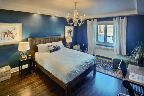 a bedroom with a bed and a blue wall at Gite du Survenant Montreal in Montréal