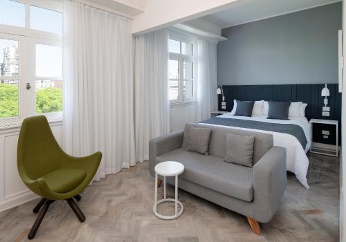 um quarto com uma cama, um sofá e uma cadeira em Palacio Paz Boutique Hotel em Buenos Aires
