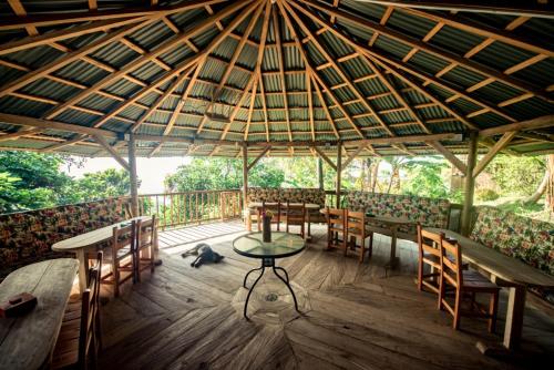 a patio with tables and chairs and a dog on the floor at Monte Mágico in Támesis