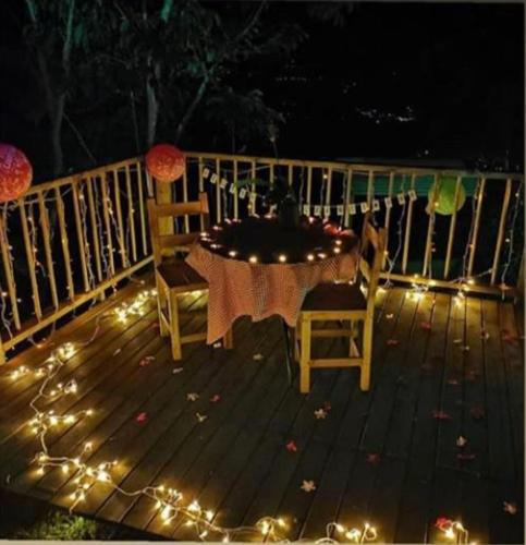a table and chairs on a deck with lights at Monte Mágico in Támesis