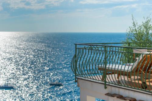 a bench sitting on a balcony overlooking the ocean at Hotel Onda Verde in Praiano