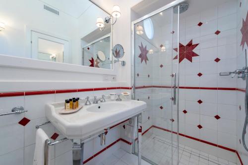 a white bathroom with a sink and a shower at Hotel Onda Verde in Praiano