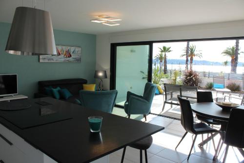 a living room with a table and chairs and a couch at O FIL DE L'EAU BANDOL - App A05 - T3 avec Jardin et terrasse in Bandol