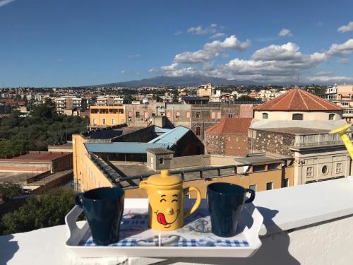 a view of a city from a balcony with two cups at Residenza Parco Gioeni in Catania