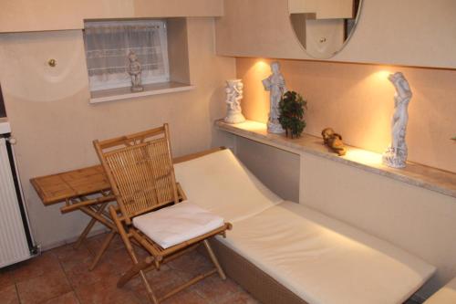 a room with a bench and a chair and a table at Parkhotel Fischer in Wernigerode