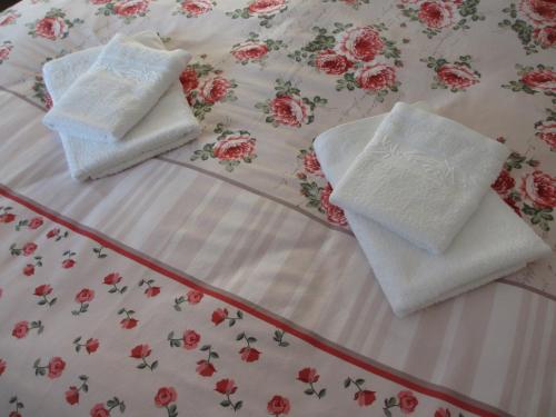 duas toalhas brancas em cima de uma cama em Apartmány U Procházků em Cesky Krumlov