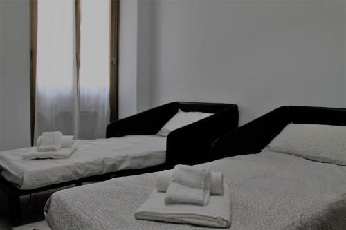 two beds in a room with towels on them at Rhome202 in Rome