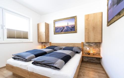 Bett mit vier Kissen auf einem Zimmer in der Unterkunft Ferienwohnung Alpenherz in Neustift im Stubaital