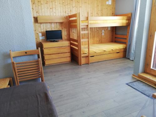 a room with two bunk beds and a television at Studio 1 pièce PLAGNE VILLAGE 4 personnes 2050 M PIED DES PISTES in Plagne Villages