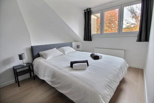 1 dormitorio con cama blanca y ventana en Rent a flat - Montgomery en Bruselas