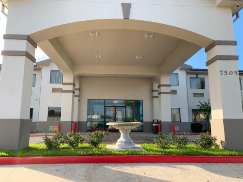 a building with a fountain in front of it at Motel 6 Houston, TX - Hwy 249 and Fallbrook in Houston
