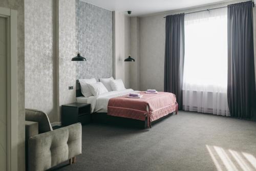 ein Hotelzimmer mit einem Bett und einem Fenster in der Unterkunft Гостиница ИВАНОВООТЕЛЬ in Iwanowo