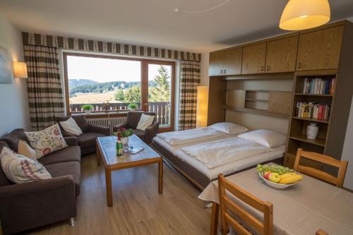 un salon avec un canapé, un lit et une table dans l'établissement Ferienwohnung Nicole, à Missen-Wilhams