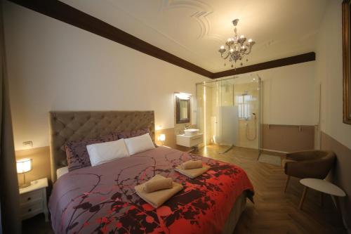 a bedroom with a large bed and a chandelier at Vitez Apartment I in Ljubljana