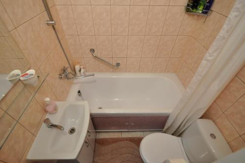 a bathroom with a tub and a toilet and a sink at Prestige Apartment in Narva