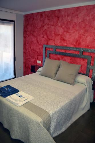 a bedroom with a large bed with a red wall at Apartamento Azero 22 in Ruidera