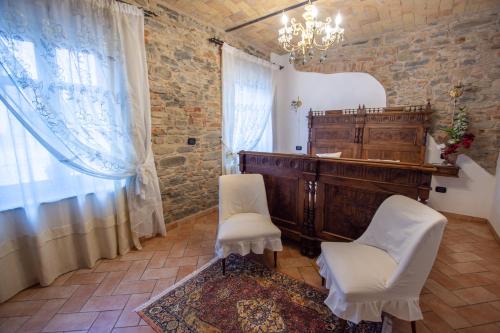 a room with a vanity and two white chairs at Cà Reginella B&B in Diano dʼAlba