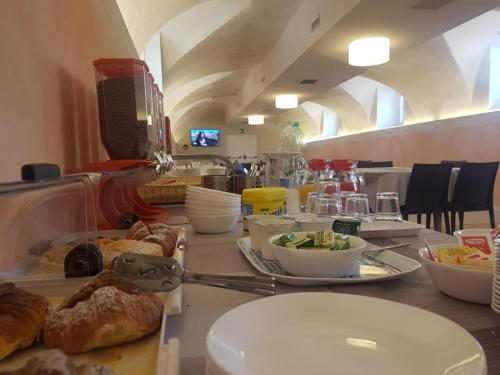 einen Tisch mit Teller mit Lebensmitteln darüber in der Unterkunft San Luigi - Residenza Gemelli in Rom