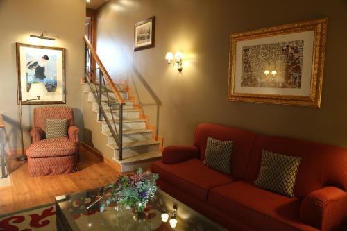 a living room with a couch and a stair case at Gran Hotel Los Abetos in Santiago de Compostela