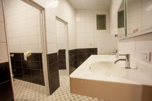 W łazience znajduje się umywalka i prysznic. w obiekcie Gene Long Haiy Att Hotel w mieście Jiayi
