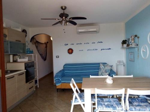 Zimmer mit einer Küche und einem Tisch mit einem Deckenventilator. in der Unterkunft happy sun apartment in Castelsardo