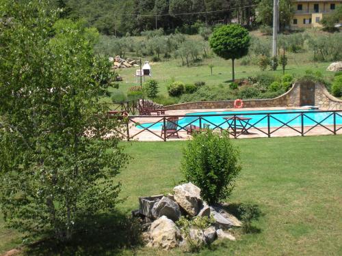 a swimming pool in a park with a tree at Azienda Agrituristica I Tre Casali in Magione