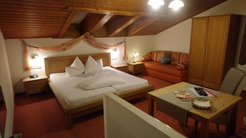 a hotel room with a bed and a couch at Pension Köhler xxx Frühstückspension incl Sommercard xxx in Jerzens
