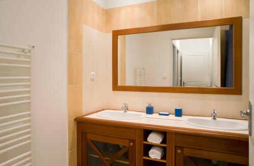 ein Badezimmer mit 2 Waschbecken und einem Spiegel in der Unterkunft Madame Vacances Les Maisons de Fontenelles in LʼAiguillon-sur-Vie