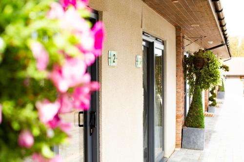 a door of a building with pink flowers in front of it at Accommodation Bristol Airport in Redhill